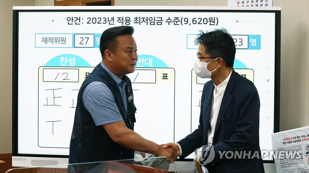 Park Joon-shik (à dr.), chef de la Commission du salaire minimum, échange une poignée de main avec Lee Dong-ho, secrétaire général de la Fédération des syndicats coréens (FKTU) au complexe gouvernemental à Sejong, le mercredi 29 juin 2022, après la huitième session plénière de la commission.
