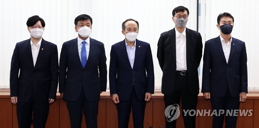 Le ministre des Finances Choo Kyung-ho (au c.) pose pour une séance photos avec le vice-président de la Commission des services financiers (FSC), Kim So-young (à g.), le conseiller présidentiel aux affaires économiques, Choi Sang-mok (2e depuis la g.), le gouverneur de la Banque de Corée (BOK), Rhee Chang-yong (2e depuis la dr.), et le patron du Service de surveillance financière (FSS), Lee Bok-hyun, le lundi 4 juillet 2022. 
