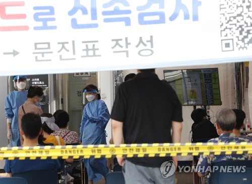 Des citoyens attendent de subir un test de dépistage pour le nouveau coronavirus (Covid-19) au centre médical public de Gangnam, dans le sud de Séoul, le vendredi 15 juillet 2022. 