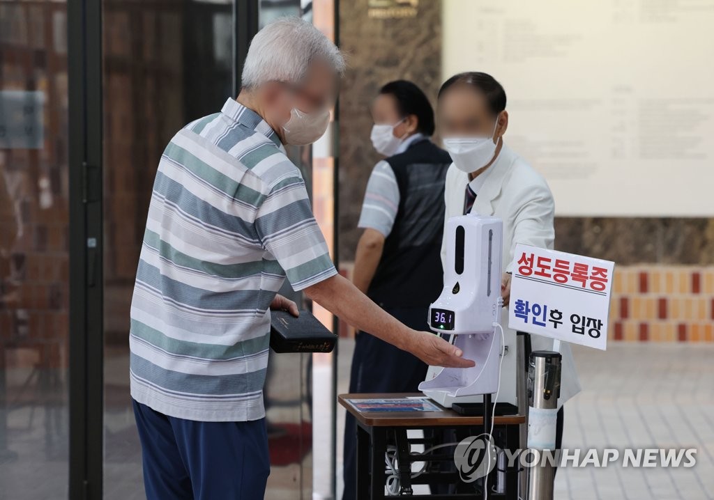 A man checks his temperature at a Seoul church on July 17, 2022, amid the spread of the omicron subvariant BA.5. (Yonhap)