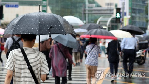 지난 18일 오전 부산도시철도 동래역 인근에서 시민들이 우산을 쓰고 발걸음을 재촉하고 있다. [연합뉴스 자료사진]