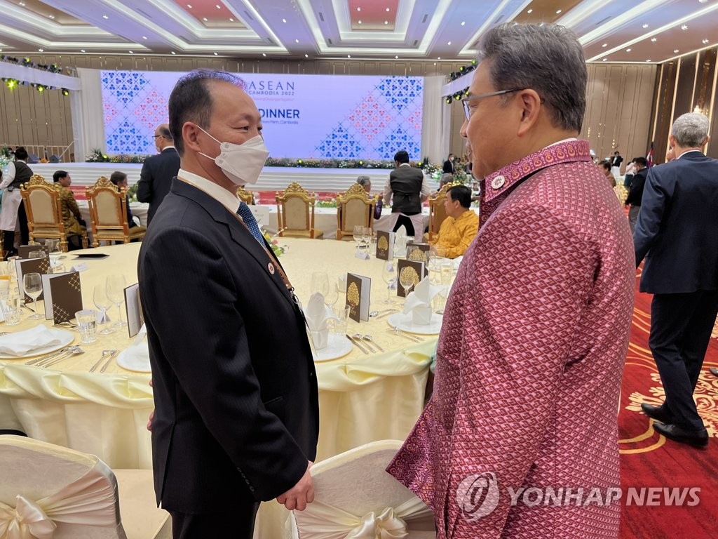 Le ministre des Affaires étrangères Park Jin (à dr.) parle le jeudi 4 août 2022 avec l'ambassadeur de Corée du Nord en Indonésie, An Kwang-il, qui cumule le poste de représentant auprès de l'Association des nations de l'Asie du Sud-Est (Asean), lors d'une réception pour les ministres des Affaires étrangères participant au Forum régional de l'Asean (ARF) à Phnom Penh, au Cambodge. Pyongyang aurait envoyé An à la place de sa chef de la diplomatie, Choe Son-hui, au premier ARF en personne en trois ans. (Photo fournie par le ministère des Affaires étrangères. Revente et archivage interdits)