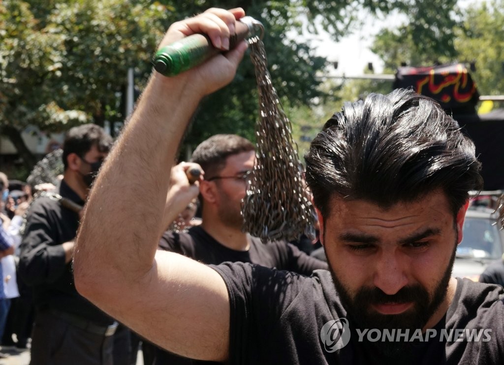 '아슈라' 맞아 쇠사슬로 어깨 내리치는 이란인
