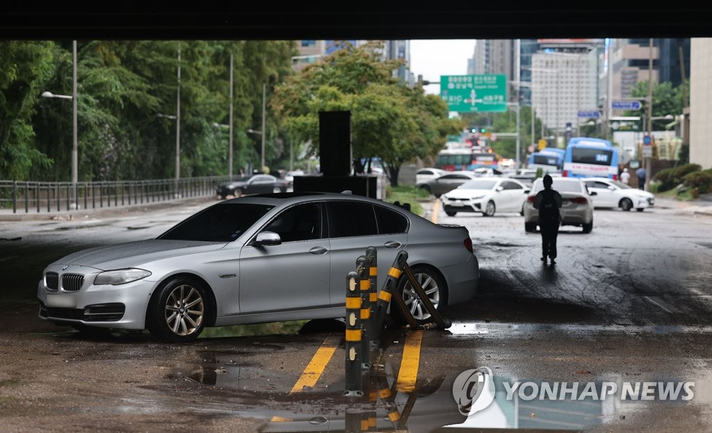 Une voiture qui a été inondée par de fortes pluies se trouve le mardi 9 août 2022 dans une rue de l'arrondissement de Seocho, dans le sud de Séoul. 