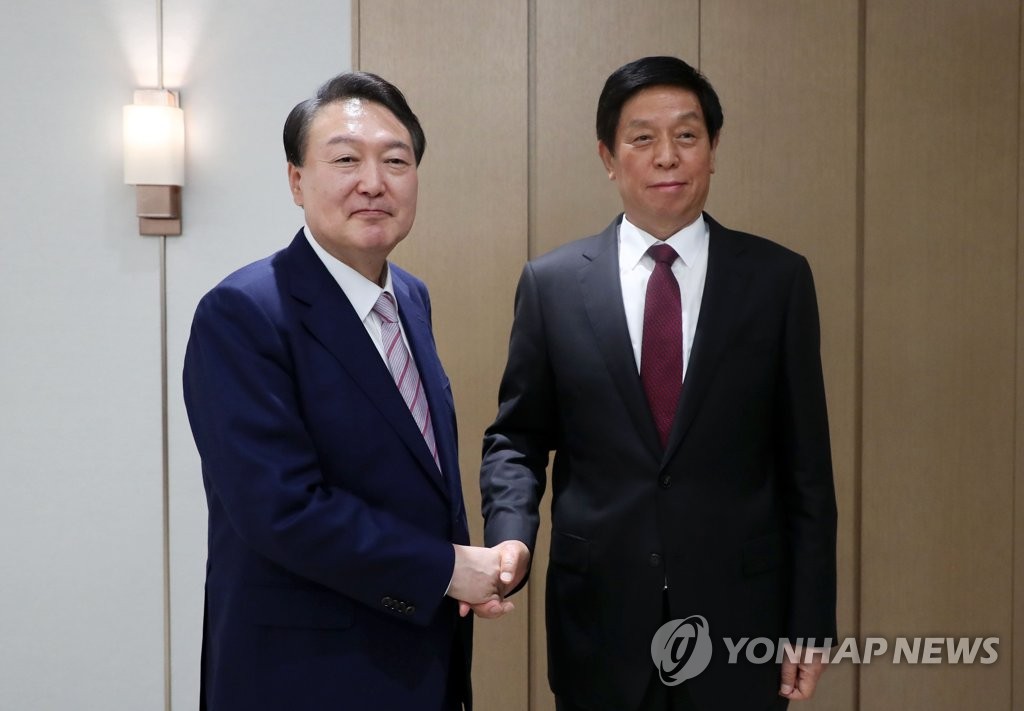 South Korean President Yoon Suk-yeol (L) shakes hands with China's top legislator Li Zhanshu during a meeting at the presidential office in Seoul on Sept. 16, 2022. (Pool photo) (Yonhap)