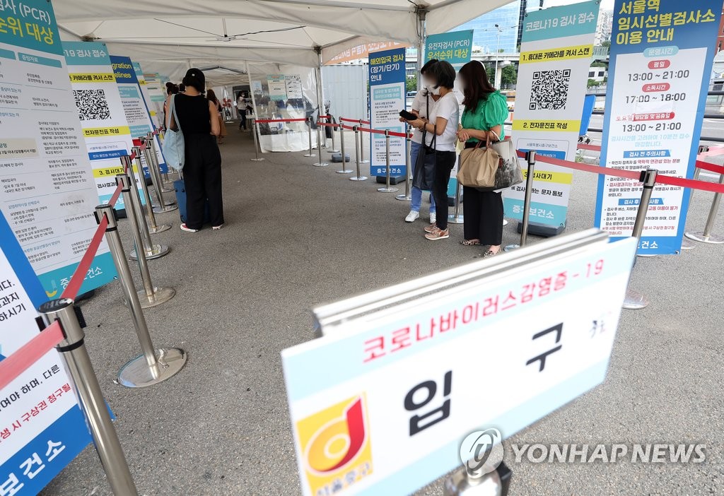 In this file photo, a couple of people wait to take a COVID-19 test at a clinic near Seoul Station in central Seoul amid eased virus curbs on Sept. 18, 2022. (Yonhap)