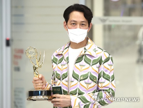 South Korean actor Lee Jung-jae, who won best drama series actor with "Squid Game" at this year's Primetime Emmy Awards, poses for a photo with his Emmy trophy upon arrival at Incheon International Airport in Incheon, west of Seoul, on Sept. 18, 2022. (Yonhap)