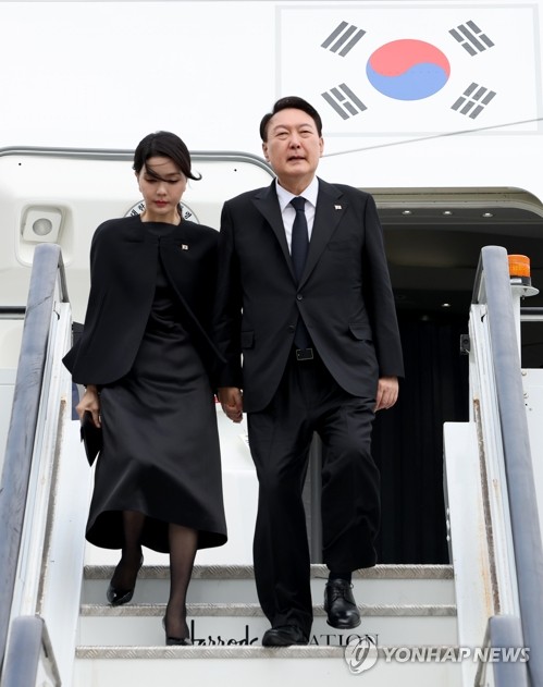 South Korean President Yoon Suk-yeol (R) and his wife, Kim Keon-hee, arrive at London Stansted Airport on Sept. 18, 2022, to attend Queen Elizabeth II's state funeral. (Yonhap)