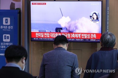 Des gens regardent sur la chaîne de télévision Yonhap News TV des informations sur le tir d'un missile balistiques de portée intermédiaire nord-coréen, à la gare de Séoul le mardi 4 octobre 2022. 