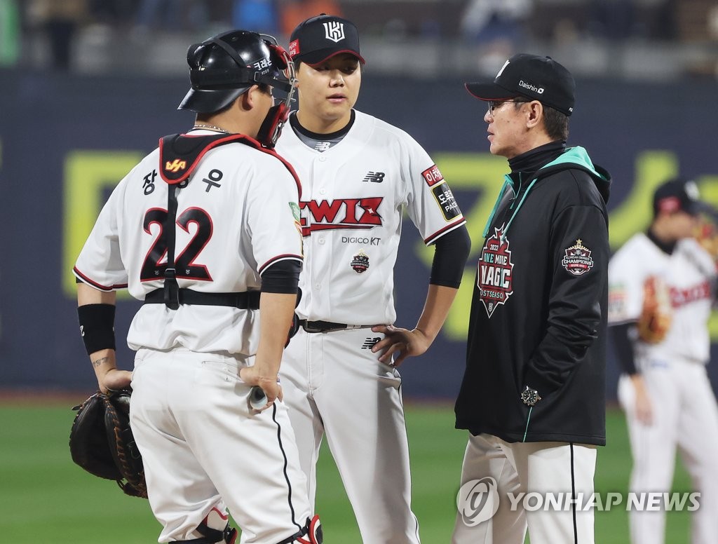 In this file photo from Oct. 20, 2022, KT Wiz manager Lee Kang-chul (R) speaks with his pitcher So Hyeong-jun (C) and catcher Jang Sung-woo during the top of the third inning of Game 4 of the first round in the Korea Baseball Organization postseason against the Kiwoom Heroes at KT Wiz Park in Suwon, some 35 kilometers south of Seoul. (Yonhap)