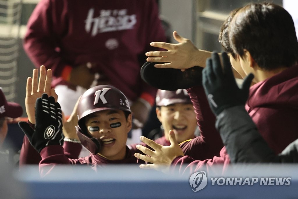 Song Sung-mun of the Kiwoom Heroes (C) is greeted by teammates after scoring a run against the LG Twins during the top of the second inning of Game 2 of the second round in the Korea Baseball Organization postseason at Jamsil Baseball Stadium in Seoul on Oct. 25, 2022. (Yonhap)