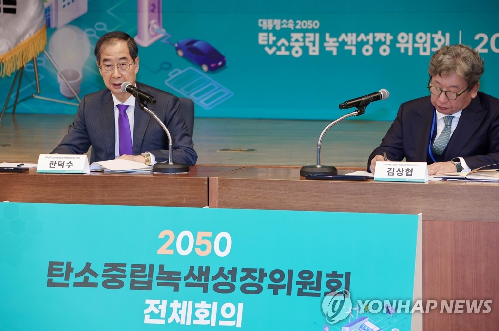 El primer ministro, Han Duck-soo (izda.), habla, el 26 de octubre de 2022, en una reunión sobre la neutralidad de carbono.