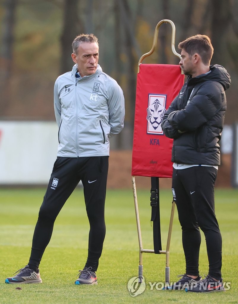 Paulo Bento (L), head coach of the South Korean men's national football team, speaks with his top assistant, Sergio Costa, during a training session at the National Football Center in Paju, Gyeonggi Province, on Oct. 28, 2022. (Yonhap)