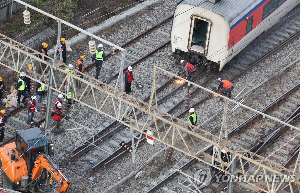 Des employés de la gare réparent une voie ferrée à la gare de Yeongdeungpo à Séoul, le 7 novembre 2022, suite au déraillement survenu la veille d'un train reliant Yongsan, dans la capitale, à Iksan, dans le sud-ouest du pays. 