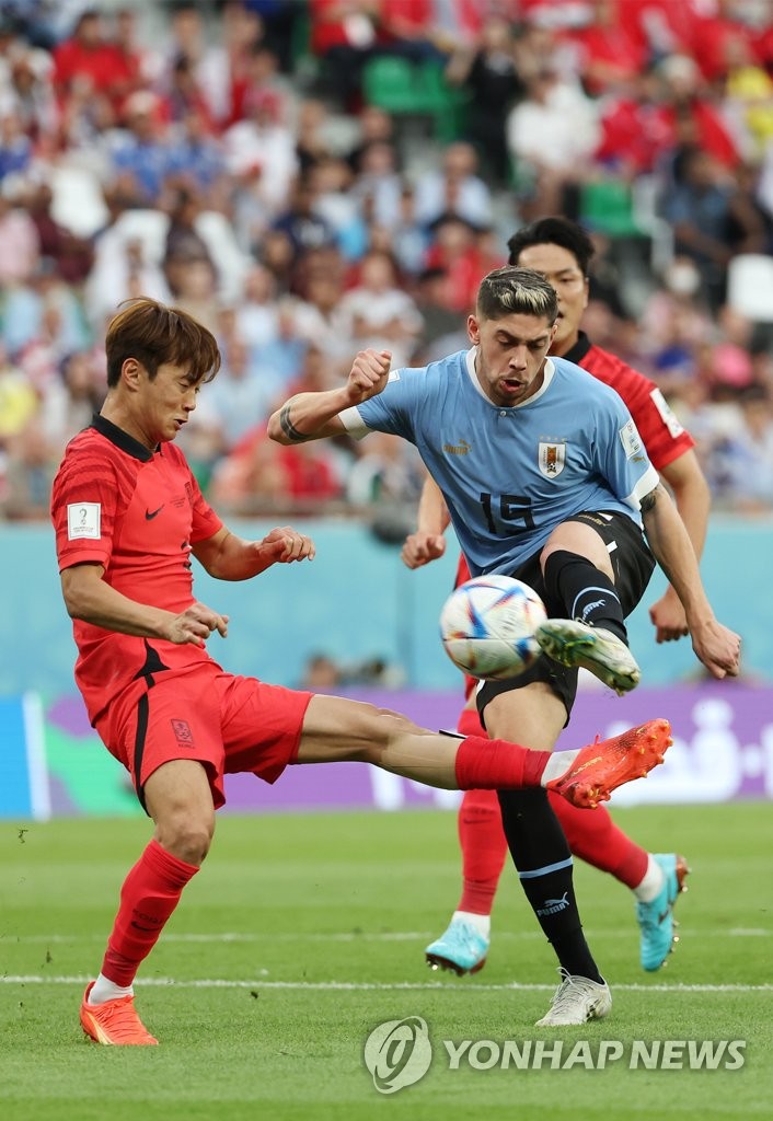 Kim Jin-su of South Korea (L) tries to block a shot attempt by Federico Valverde of Uruguay during the countries' Group H match at the FIFA World Cup at Education City Stadium in Al Rayyan, west of Doha, on Nov. 24, 2022. (Yonhap)