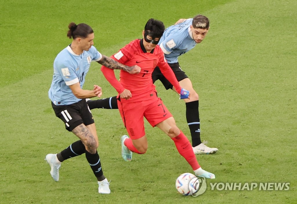 Son Heung-min of South Korea (C) tries to dribble past Darwin Nunez (L) and Federico Valverde of Uruguay during the countries' Group H match at the FIFA World Cup at Education City Stadium in Al Rayyan, west of Doha, on Nov. 24, 2022. (Yonhap)