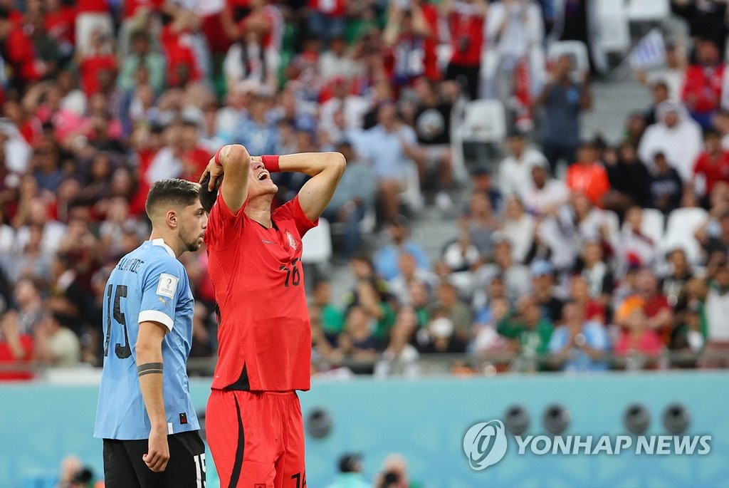 Hwang Ui-jo of South Korea (R) reacts to a missed scoring opportunity against Uruguay during the countries' Group H match at the FIFA World Cup at Education City Stadium in Al Rayyan, west of Doha, on Nov. 24, 2022. (Yonhap)