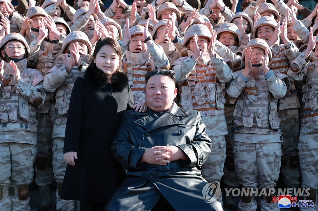 This photo, released by the Korean Central News Agency on Nov. 27, 2022, shows North Korean leader Kim Jong-un (front, R) with his daughter during a photo session with officials involved in this month's intercontinental ballistic missile launch. (For Use Only in the Republic of Korea. No Redistribution) (Yonhap)