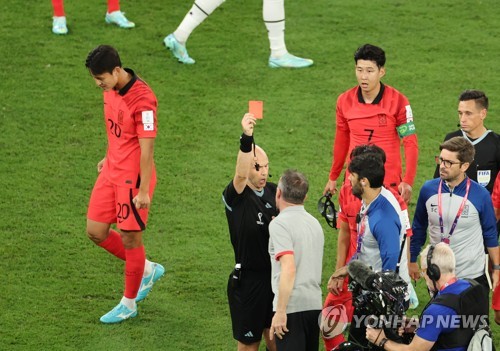 El director técnico de Corea del Sur, Paulo Bento (centro), recibe una tarjeta roja de parte del árbitro Anthony Taylor, el 28 de noviembre de 2022, luego de la culminación del partido entre su equipo y Ghana, en el grupo H de la Copa Mundial, en el estadio de la Ciudad de la Educación, al oeste de Doha.