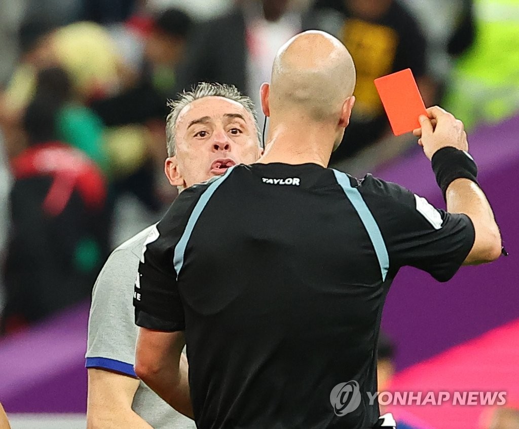 South Korea head coach Paulo Bento (L) receives a red card from referee Anthony Taylor following South Korea's 3-2 loss to Ghana in Group H at the FIFA World Cup at Education City Stadium in Al Rayyan, west of Doha, on Nov. 28, 2022. (Yonhap)