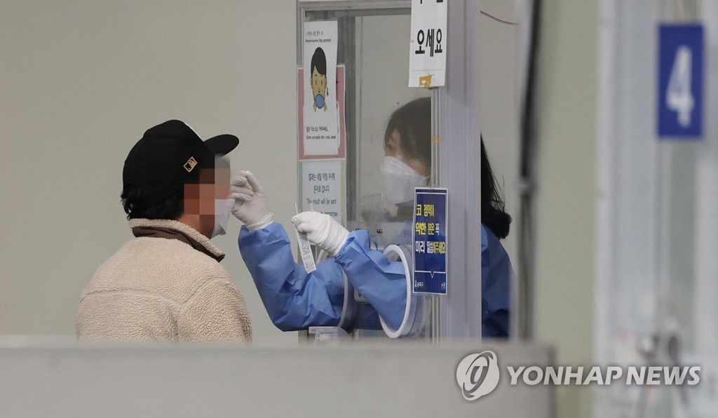 This file photo taken on Nov. 20, 2022, shows a man taking a virus test at a community health center in Seoul's eastern district of Songpa. (Yonhap)