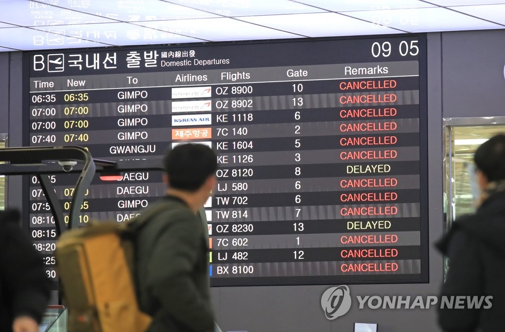 A flight information display system at Jeju International Airport in Jeju shows cancellations or delays for multiple flights on Dec. 18, 2022, due to major snowfall and strong wind warnings. (Yonhap)