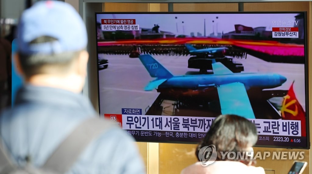 People watch TV news about a North Korean drone that infiltrated South Korean airspace at Seoul Station in central Seoul on Dec. 27, 2022. (Yonhap)