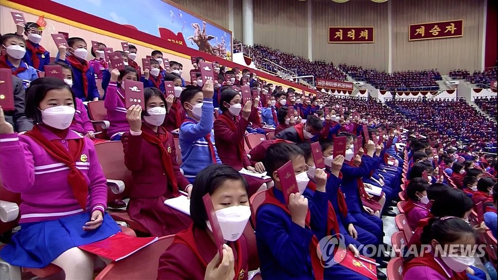대표증 들어보이는 북한 소년단원들