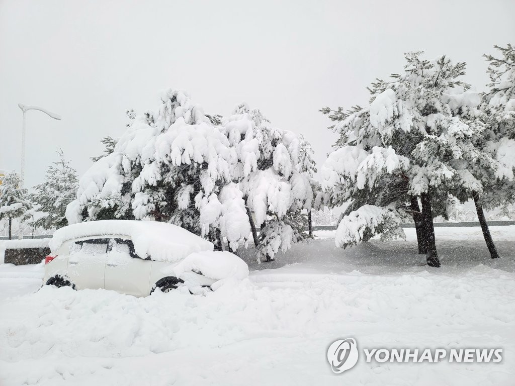 Une voiture est bloquée dans la neige à Sokcho, dans la province du Gangwon, le dimanche 15 janvier 2023.