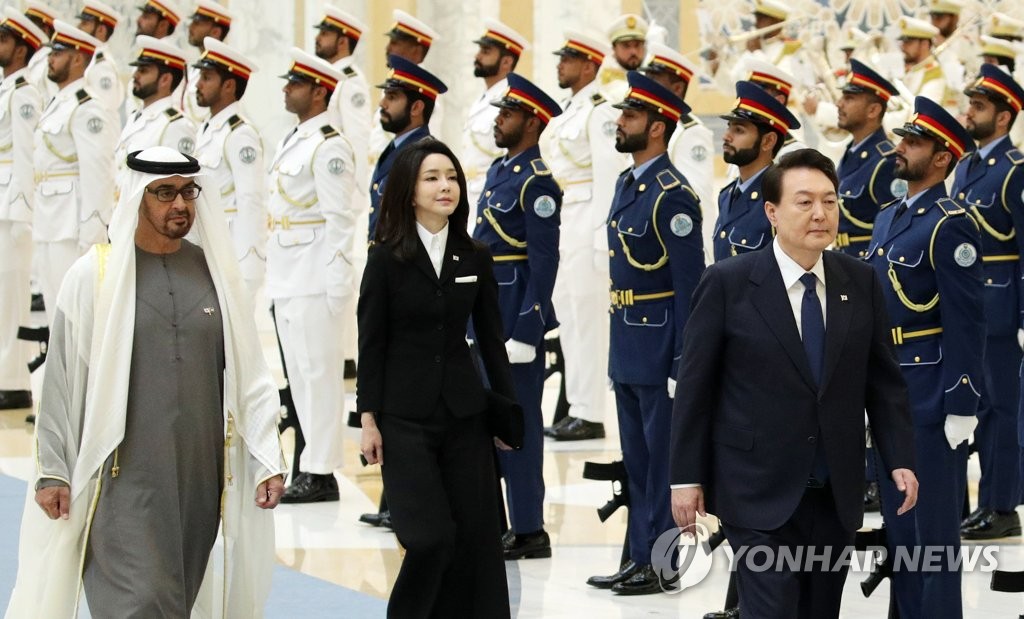 El presidente surcoreano, Yoon Suk Yeol (frente), la primera dama, Kim Keon Hee (segunda por la izda., fondo), y el presidente de los EAU, Mohamed bin Zayed Al Nahyan, pasan revista a la guardia de honor durante una ceremonia de bienvenida oficial, celebrada, el 15 de enero de 2023 (hora local), en el palacio presidencial Qasr Al Watan, en Abu Dabi, los Emiratos Árabes Unidos (EAU). 