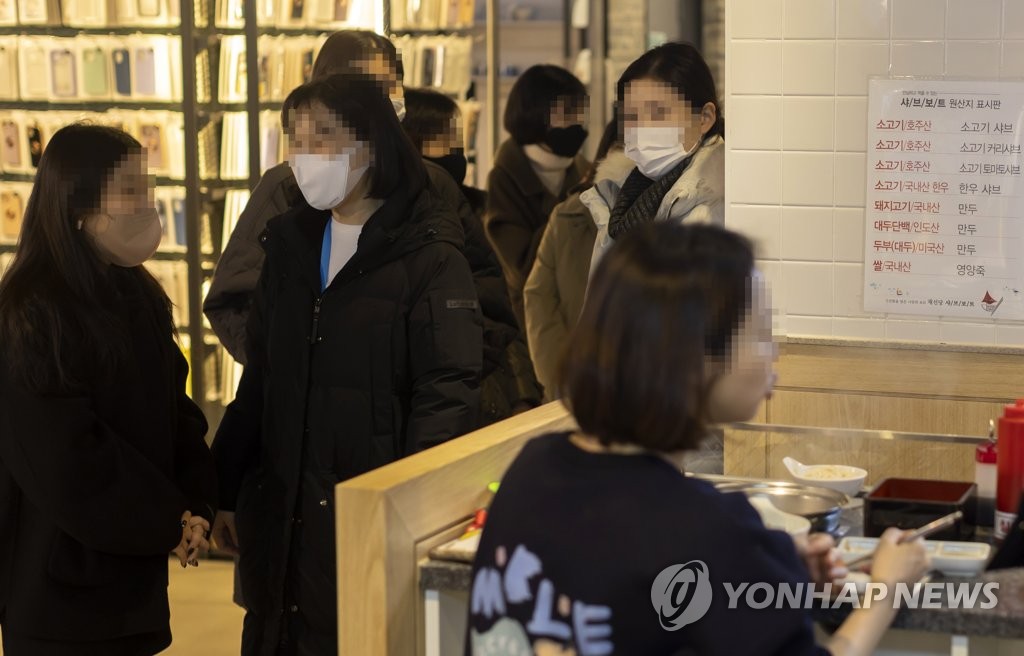 Des citoyens portant un masque de protection font la queue dans un restaurant à Séoul le mardi 17 janvier 2023. 