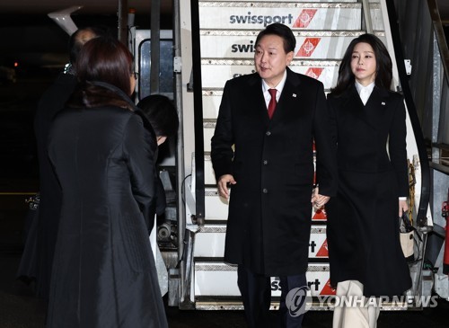 El presidente surcoreano, Yoon Suk Yeol (segundo por la dcha.), y la primera dama, Kim Keon Hee (dcha.), llegan, el 17 de enero de 2023 (hora local), al Aeropuerto de Zúrich, en Suiza. 