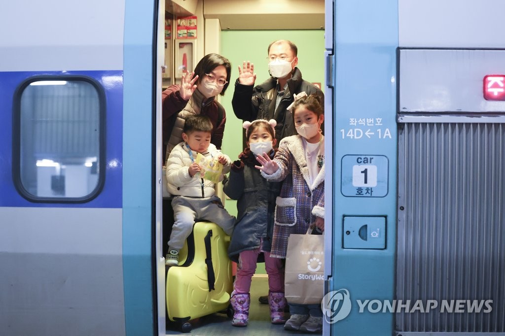 旧正月連休前日、ソウル駅で列車に乗り込む帰省客＝２０日、ソウル（聯合ニュース）