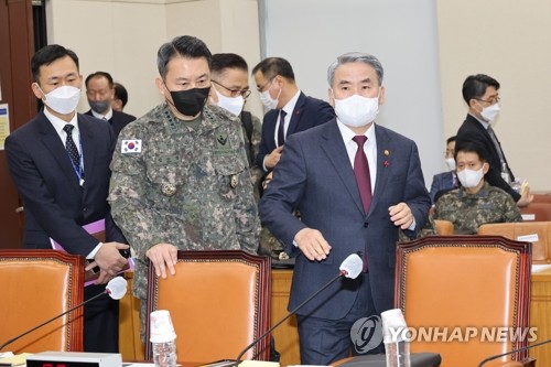 El ministro de Defensa surcoreano, Lee Jong-sup (dcha.), y el jefe de Estado Mayor Conjunto, el general Kim Seung-kyum (segundo por la izda.), toman asiento, el 26 de enero de 2023, en la Asamblea Nacional, en el oeste de Seúl, antes de informar a los legisladores sobre la inspección del Ejército, de varias semanas de duración, de la operación contra los cinco drones norcoreanos que violaron, el 26 de diciembre de 2022, el espacio aéreo surcoreano. 