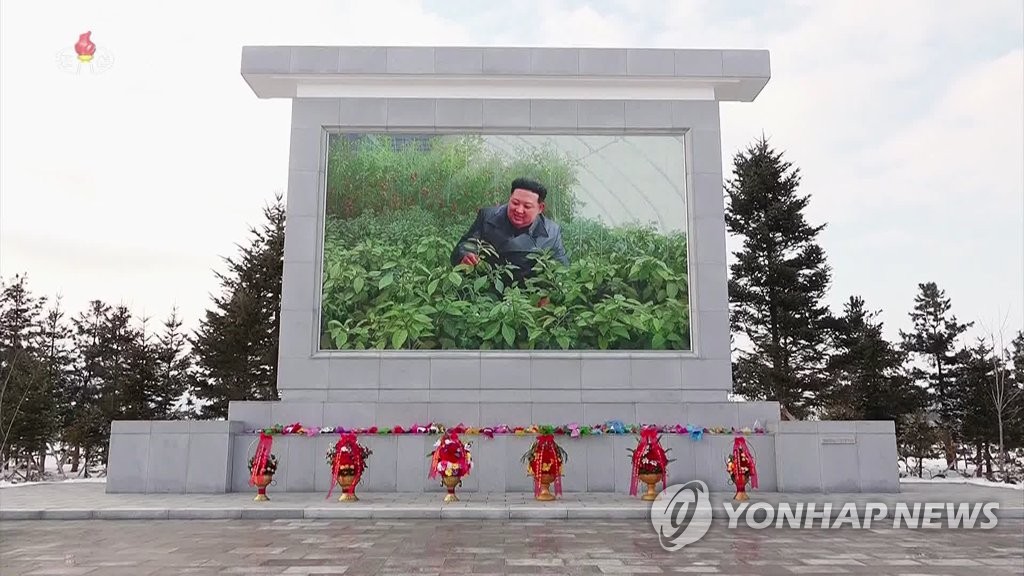 북한 주민들 '건군절' 맞아 김정은 벽화에 헌화