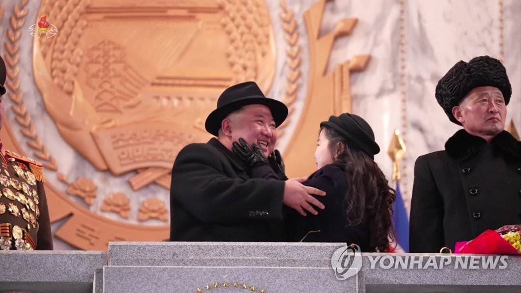 Esta imagen, tomada de imágenes de la Televisión Central Coreana de Corea del Norte el 9 de febrero de 2023, muestra al líder norcoreano Kim Jong-un (izquierda) sonriendo mientras su hija Ju-ae le toca las mejillas mientras asistía a un desfile militar el día anterior.  (Para uso exclusivo en la República de Corea. Sin redistribución) (Yonhap)