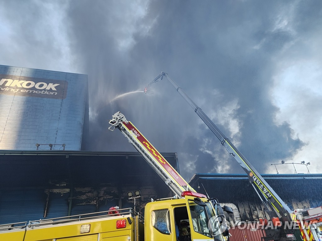Des pompiers combattent l'incendie à l'aide des camions de pompiers à l'usine de Hankook Tire & Technology Co. à Daejeon, le lundi 13 mars 2023. 