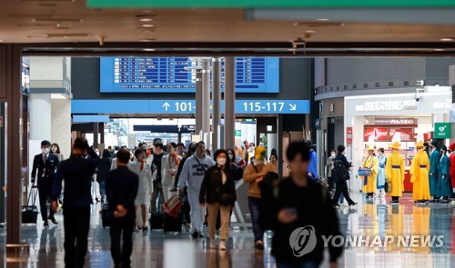 Travelers walk around the duty-free shop section inside Incheon International Airport, 49 kilometers west of Seoul, on March 20, 2023. (Yonhap)
