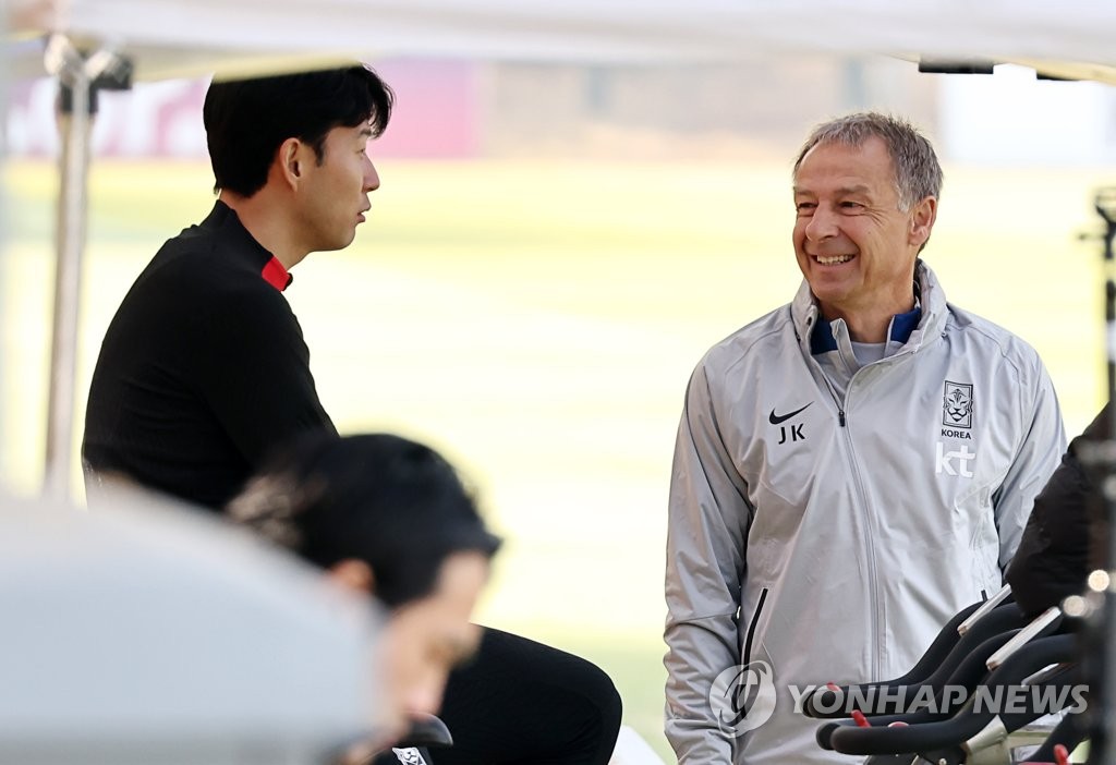 South Korea head coach Jurgen Klinsmann (C) speaks with forward Son Heung-min before a training session at the National Football Center in Paju, some 30 kilometers northwest of Seoul, on March 21, 2023. (Yonhap)