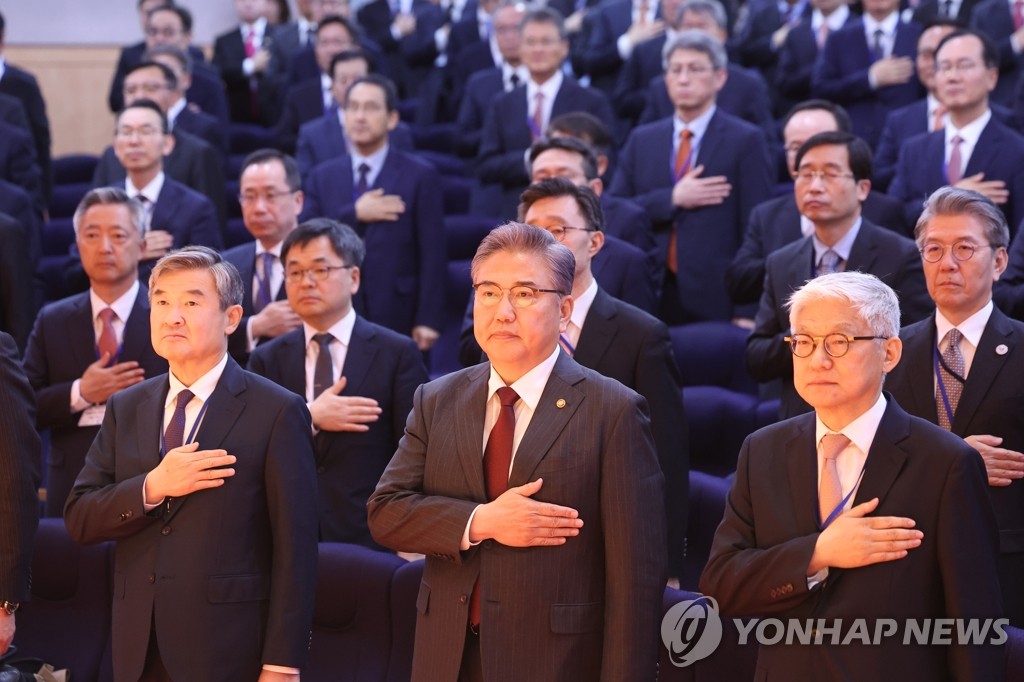 Foreign Minister Park Jin (C, 1st row), along with ambassadors and consuls general stationed abroad, salutes the national flag as they attend their annual meeting at the foreign ministry in Seoul on March 27, 2023. The meeting will run for five days. (Yonhap)