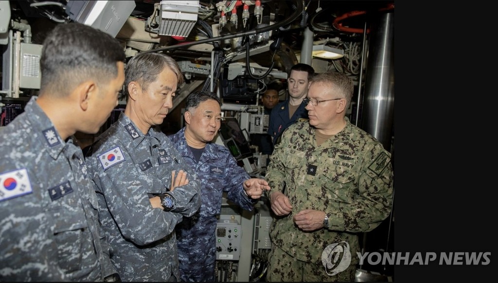 South Korean, U.S. and Japanese submarine commanders speak with one another aboard the USS Maine, an Ohio-class ballistic missile submarine, in the vicinity of Guam on April 18, 2023, in this photo posted on the Pentagon's Defense Visual Information Distribution Service. Among them are Rear Adm. Lee Su-youl (2nd from L), the commander of the South Korean Navy's Submarine Force; Rear Adm. Rick Seif (R), the commander of the U.S.' Submarine Group 7; and Vice Adm. Tateki Tawara (3rd from L). (PHOTO NOT FOR SALE) (Yonhap)