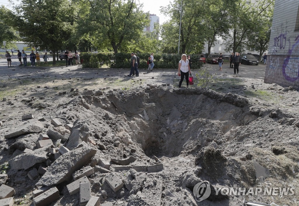 러' 미사일 충격 거대한 구멍 바라보는 우크라 주민들
