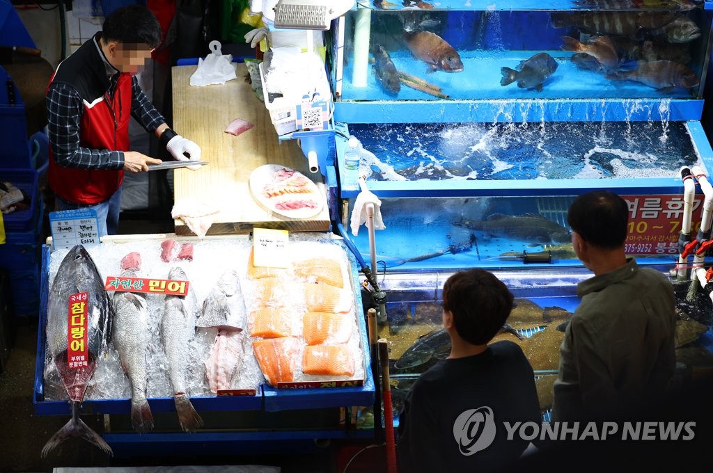 Un chef prepara un plato de mariscos en el mercado de pescado de Noryangjin en Seúl el 4 de julio de 2023. (Yonhap) 
