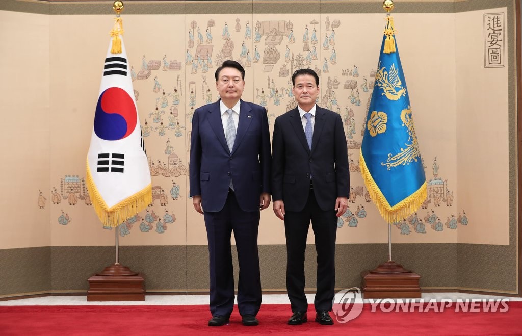 President Yoon Suk Yeol (L) poses for a photo with new Unification Minister Kim Yung-ho after presenting him a letter of appointment at the presidential office in Seoul on July 28, 2023. (Pool photo) (Yonhap)