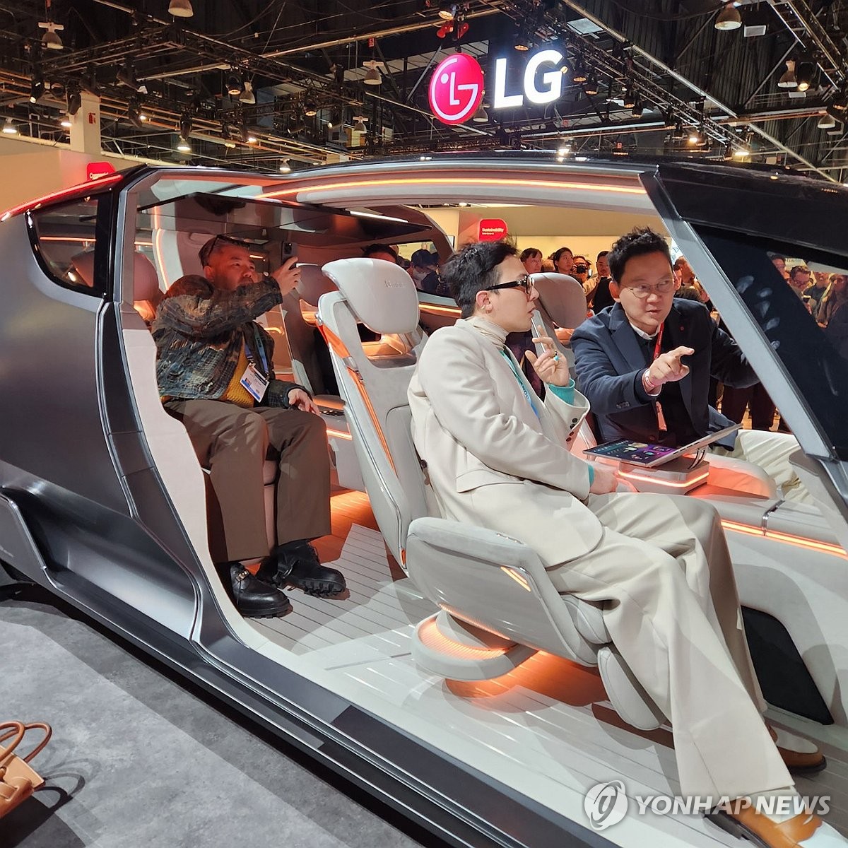 K-pop star G-Dragon (C) experiences LG Electronics Co.'s future concept car, Alpha-ble, at the Las Vegas Convention Center in Las Vegas on Jan. 9, 2024, during CES 2024. (Yonhap)