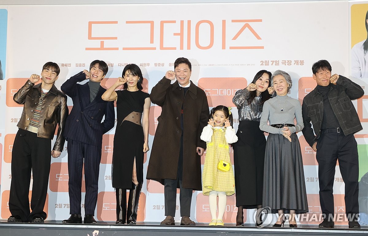 The cast and director of the Korean drama film "Dog Days" pose for photographers during a press conference to promote the project in Seoul on Jan. 10, 2024. (Yonhap)