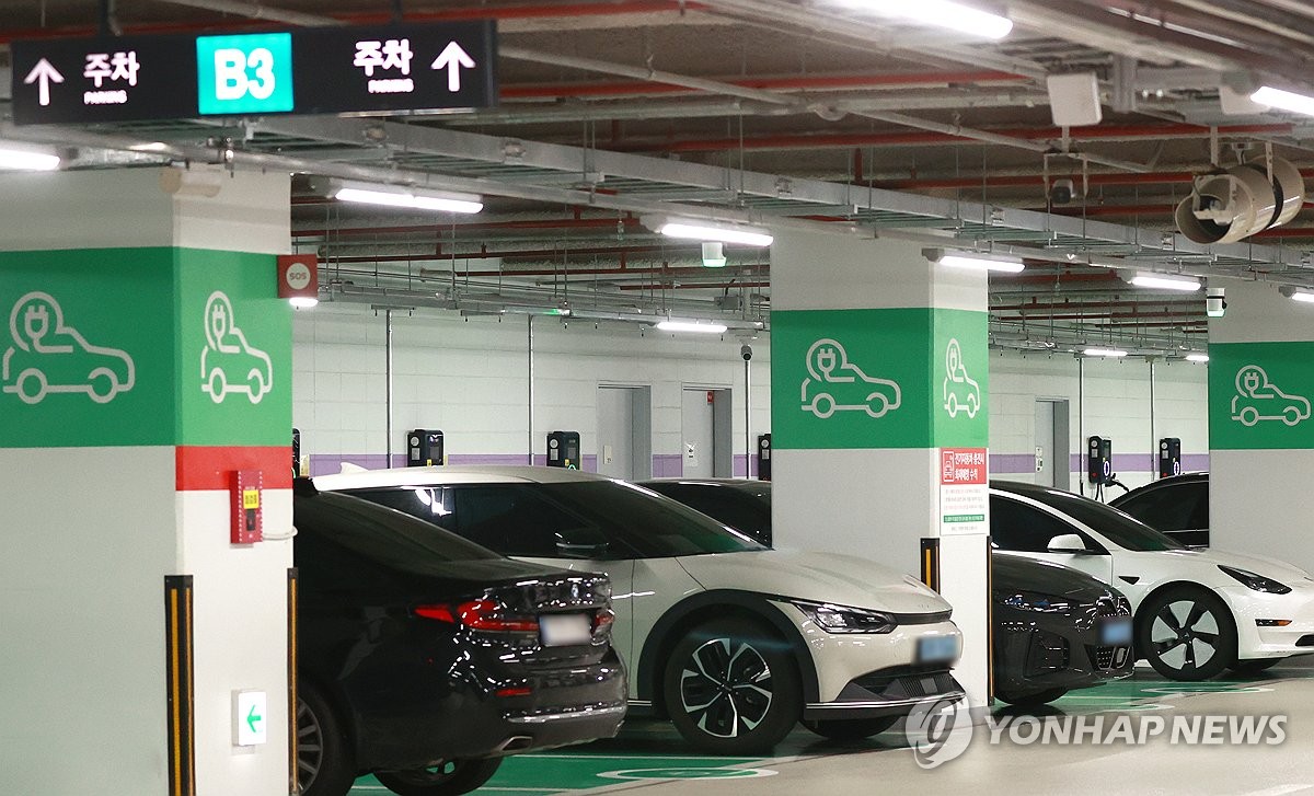 Esta foto de archivo del 9 de mayo de 2024 muestra vehículos eléctricos cargándose en un estacionamiento de Seúl. (Yonhap)