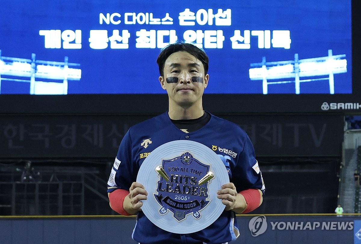 Son Ah-seop of the NC Dinos holds the plaque commemorating his 2,505th career hit, a new Korea Baseball Organization record, during a regular-season game against the Doosan Bears at Jamsil Baseball Stadium in Seoul on June 20, 2024. (Yonhap)