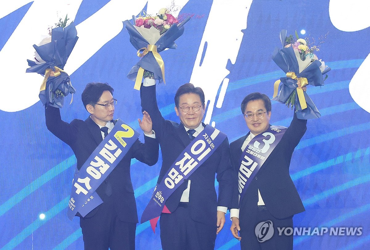 Lee Jae-myung (C), former leader of the Democratic Party, greets party members, along with former South Gyeongsang Gov. Kim Kyoung-soo (L) and Gyeonggi Gov. Kim Dong-yeon, after winning the party's presidential nomination following a primary event in the city of Goyang, just north of Seoul, on April 27, 2025. (Yonhap)