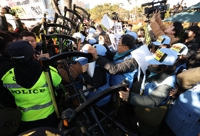 もみ合う旅客機事故の遺族と警察